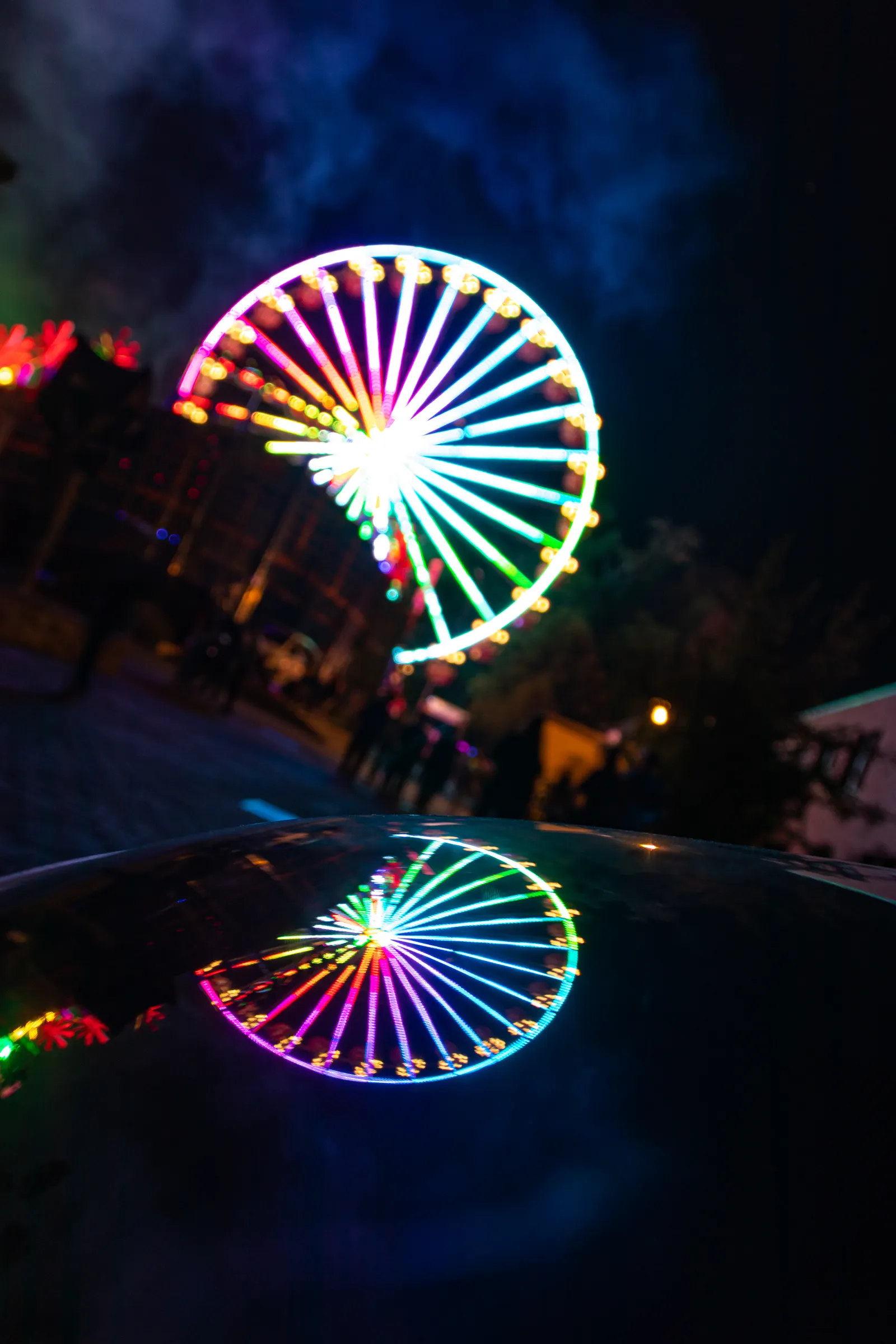 Beleuchtetes Riesenrad bei Nacht auf einem Volksfest