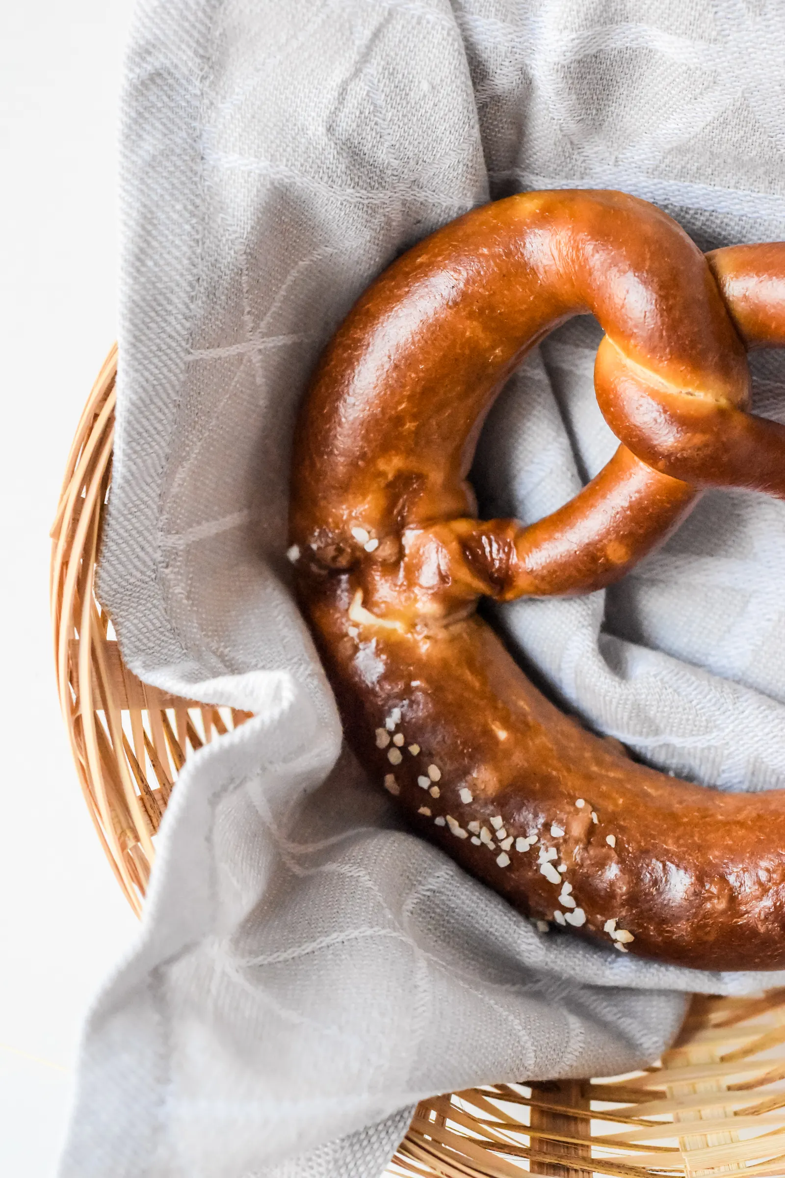 Frisch gebackene Brezel mit Salz liegt in einem Korb mit Tuch