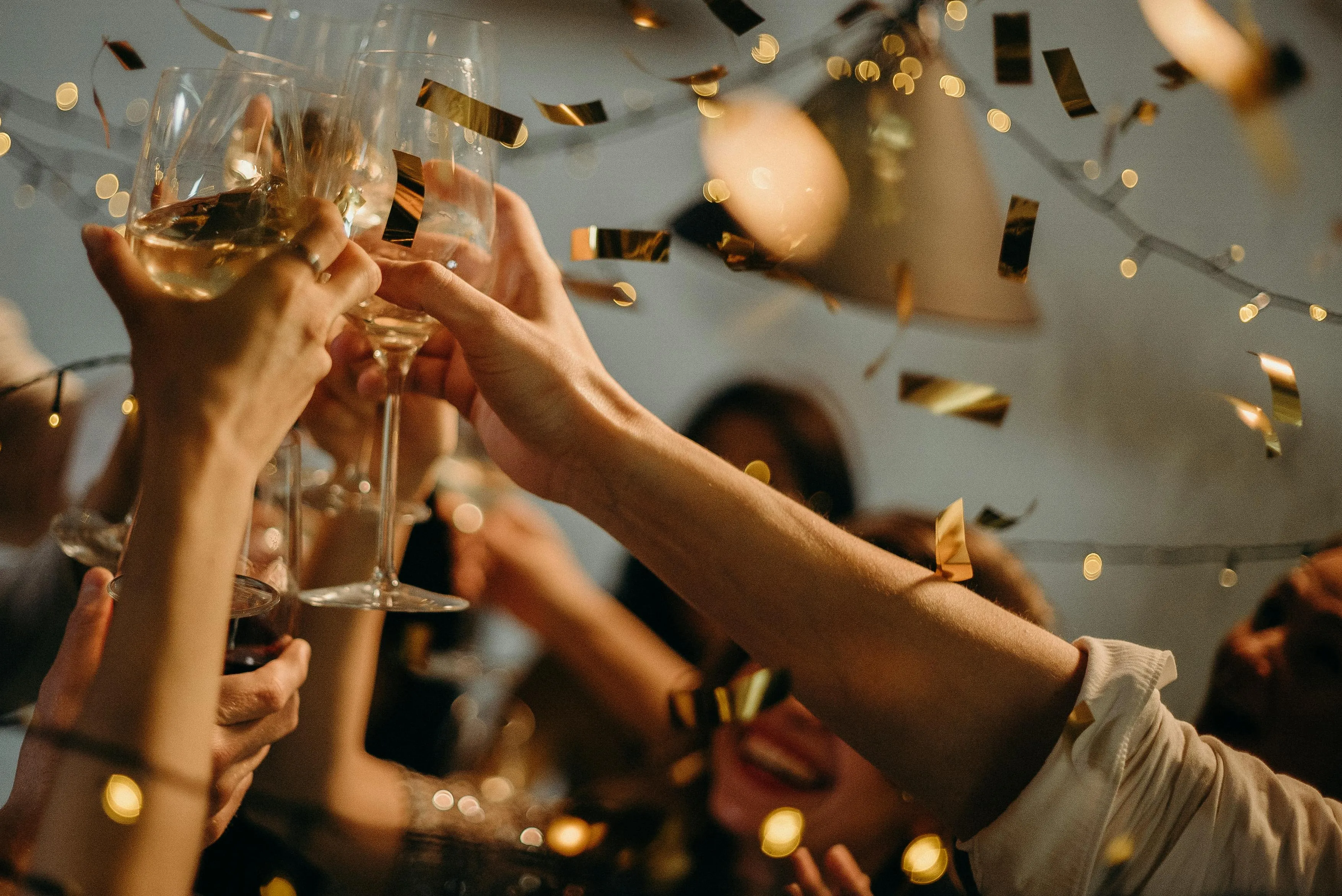 Gruppe von Personen stößt mit Weingläsern an bei einer festlichen Feier – Team-Toast beim Firmenjubiläum